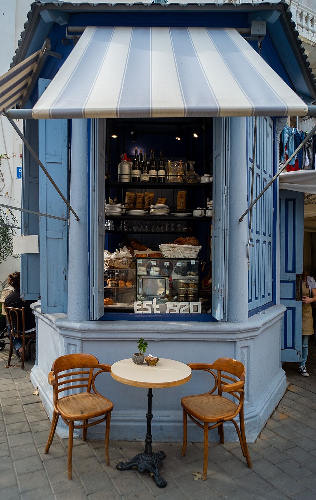 Cafe Nechama blue storefront with striped awning on Dizengoff Street