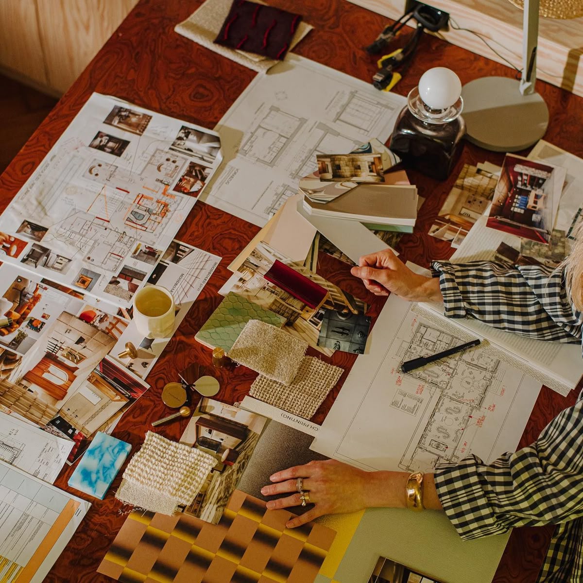 Creative workspace with mood boards, color swatches and design materials on wood desk